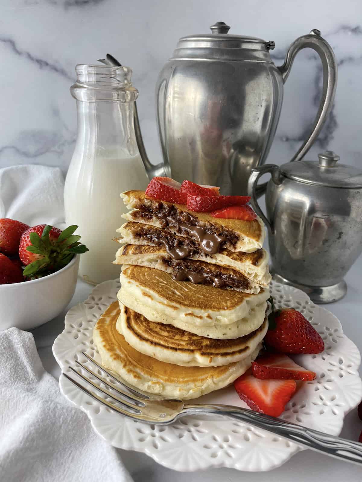 Stack of Nutella pancakes with strawberries.
