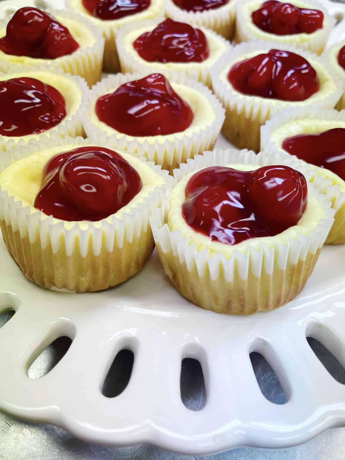 Mini cheesecakes with cherry pie filling on top.