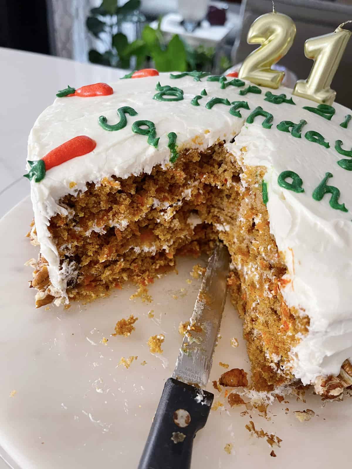 Carrot cake with several slices already cut out of it.