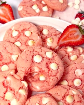 The best strawberry cake mix cookies on a plate with white chocolate chips.