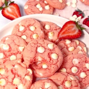 The best strawberry cake mix cookies on a plate with white chocolate chips.