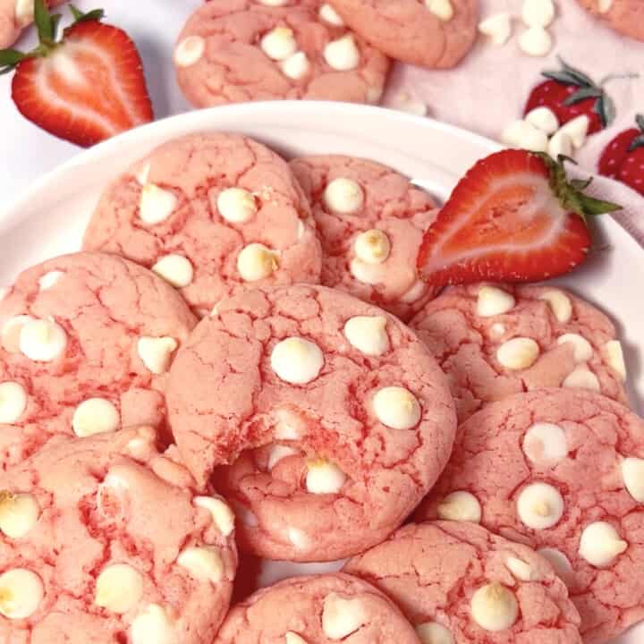 The best strawberry cake mix cookies on a plate with white chocolate chips.