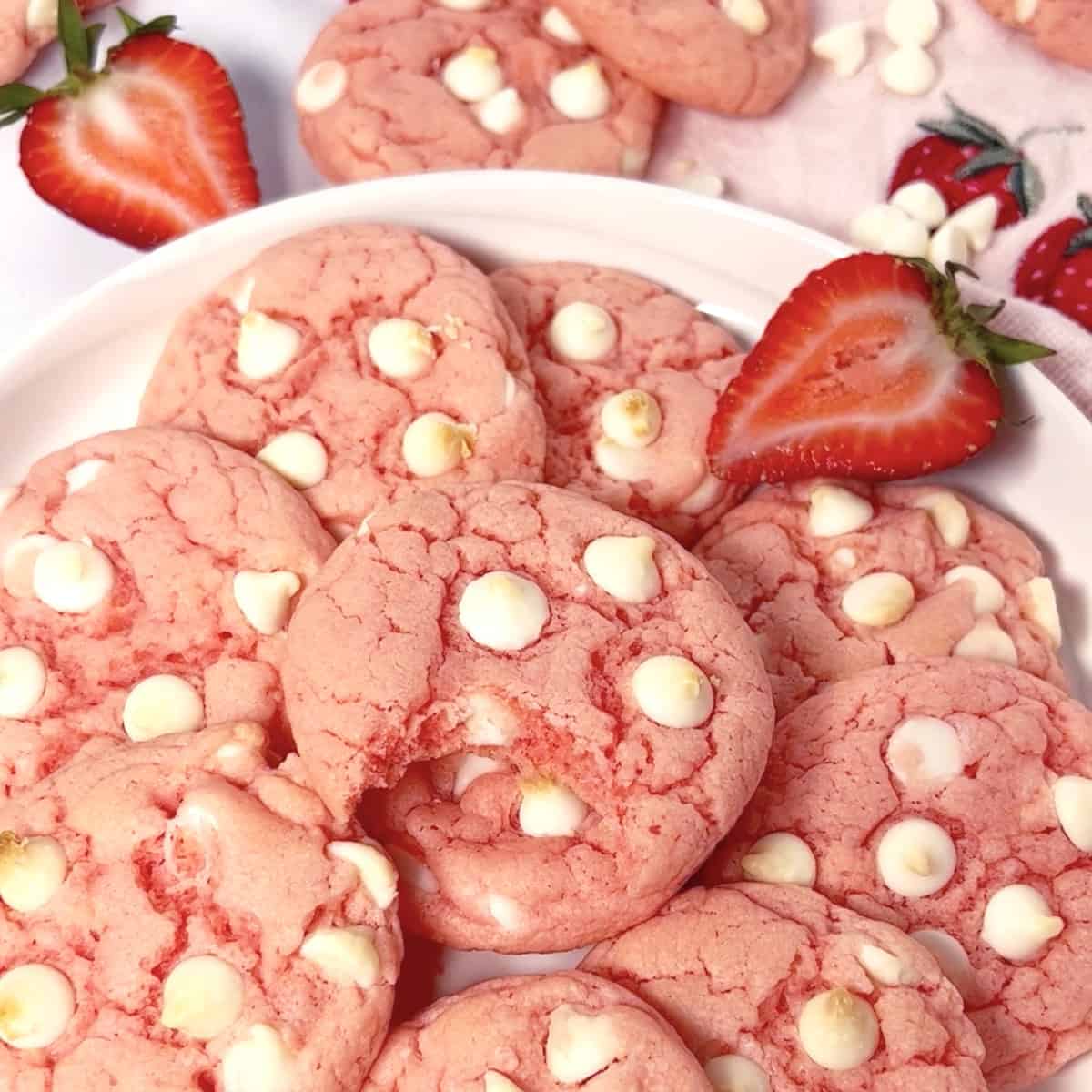 The best strawberry cake mix cookies on a plate with white chocolate chips.