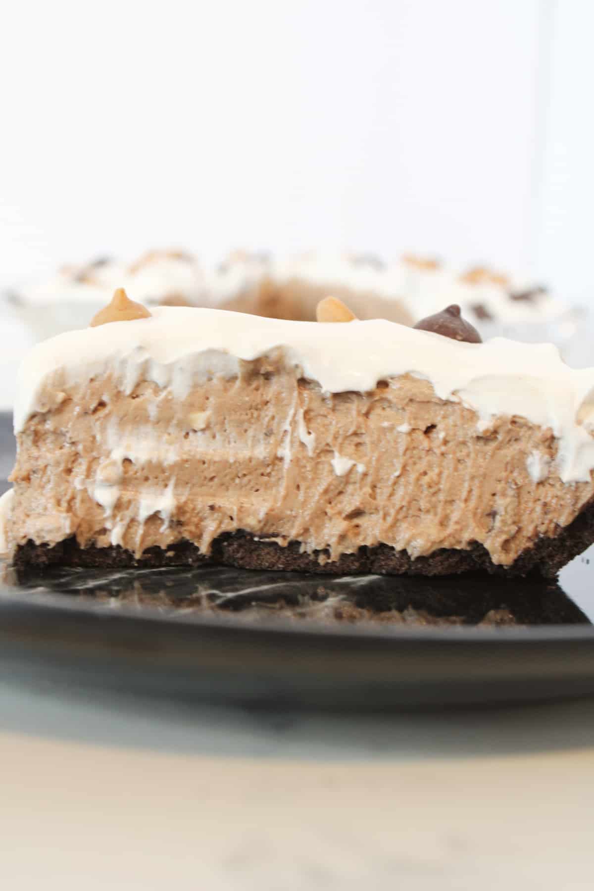Slice of no bake chocolate peanut butter pie on a plate.