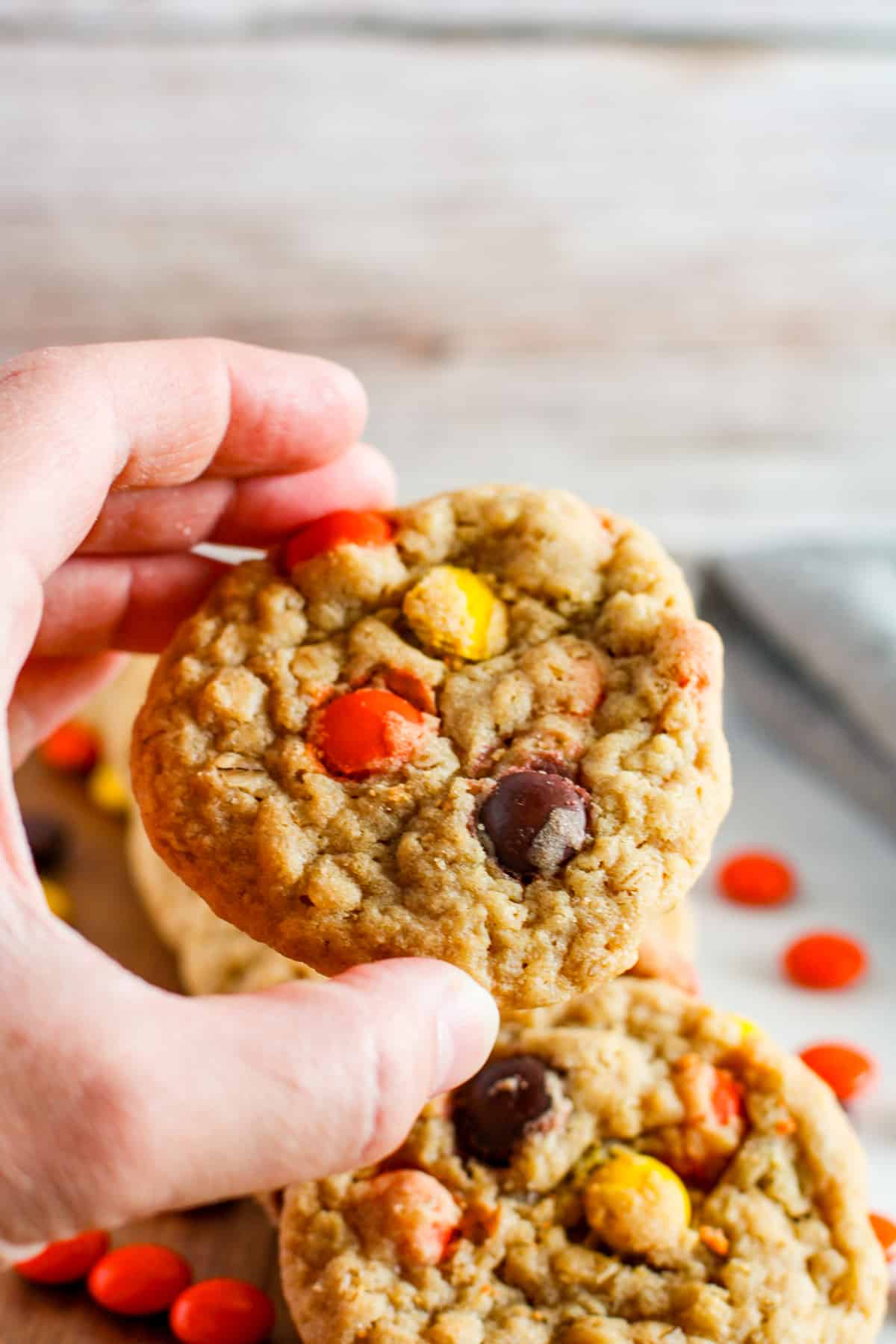 Hand holding a Reese pieces cookie.