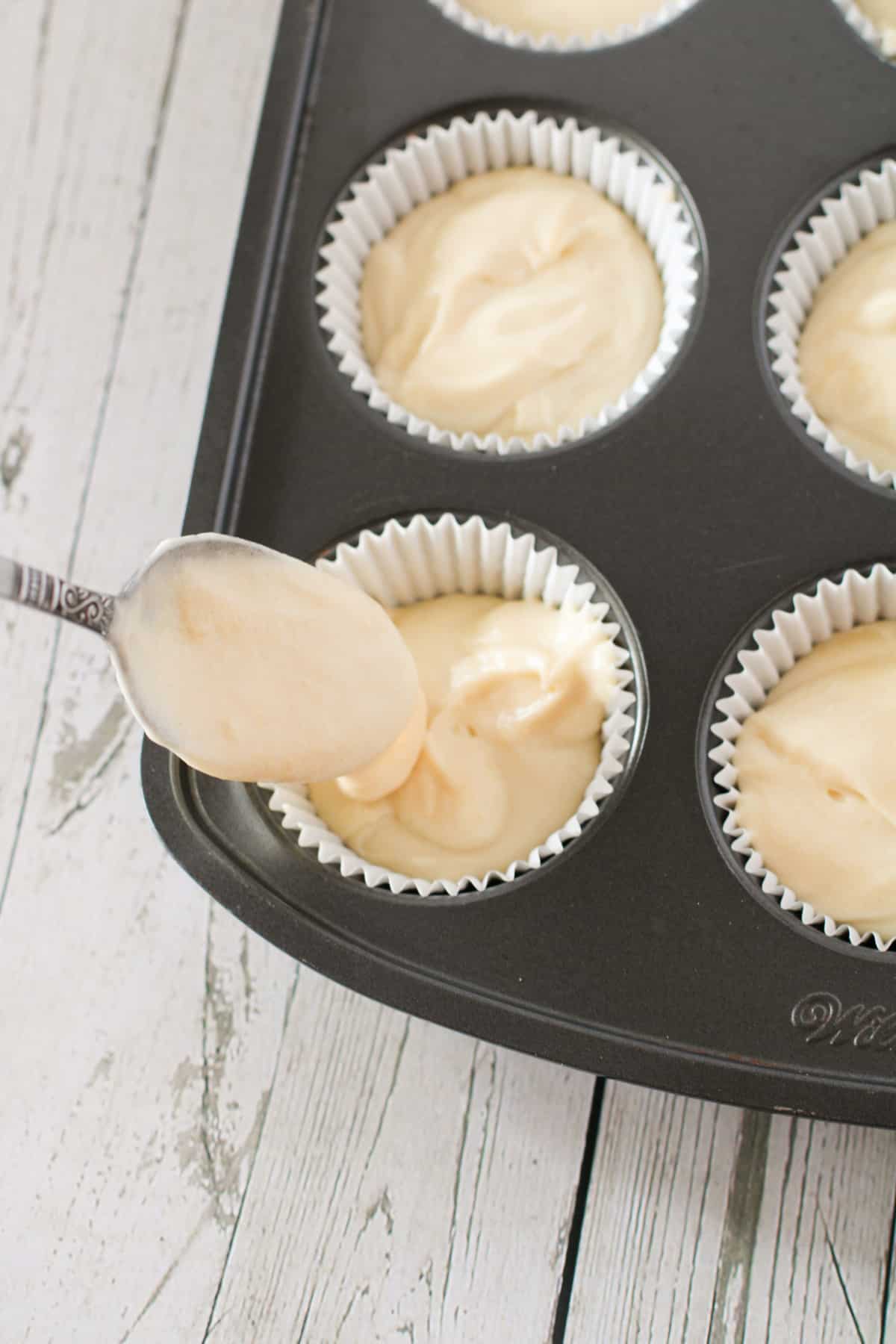 Putting cupcake batter in pan.