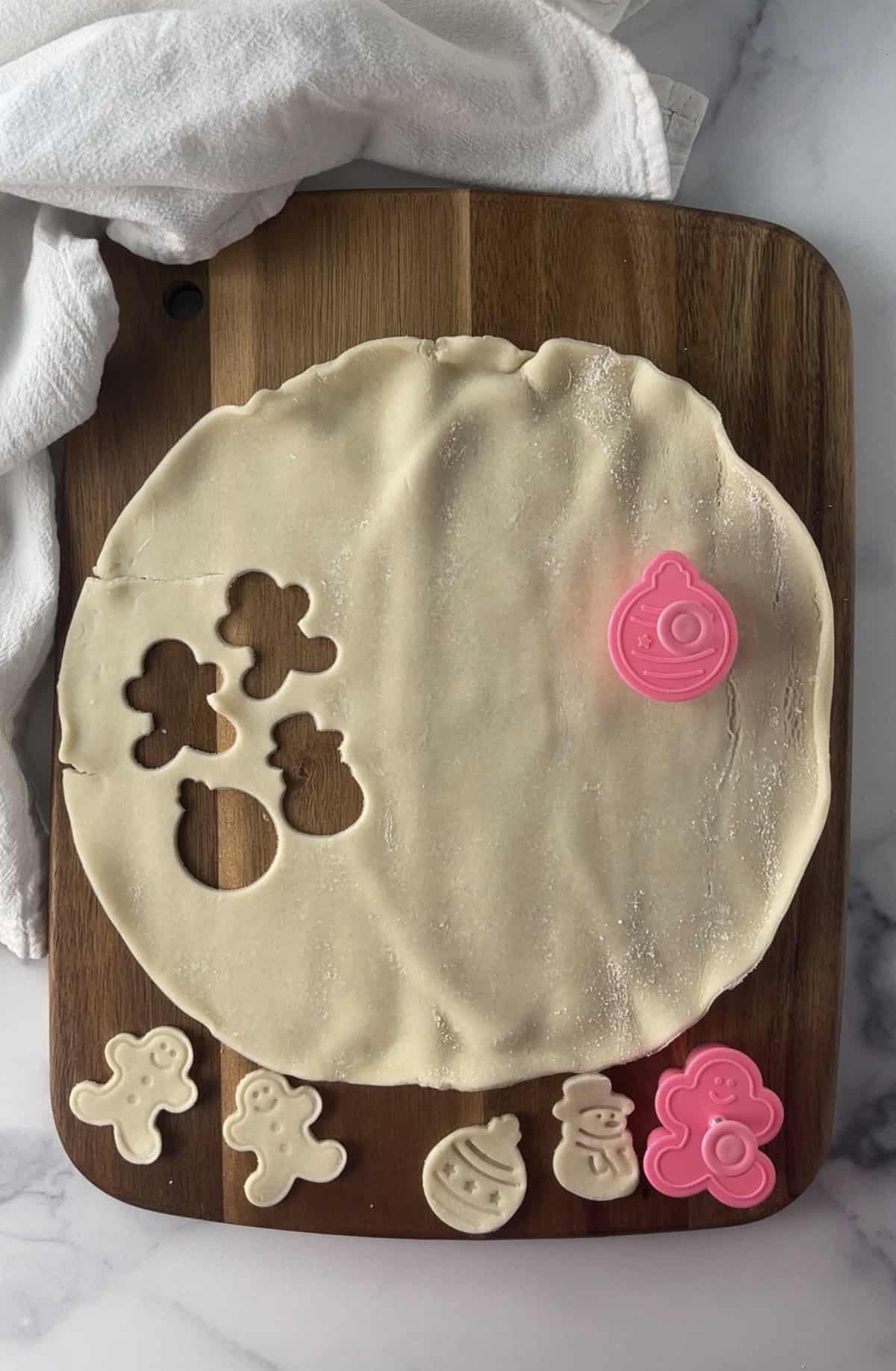 Cutting cookie cutter shapes in pie crust.