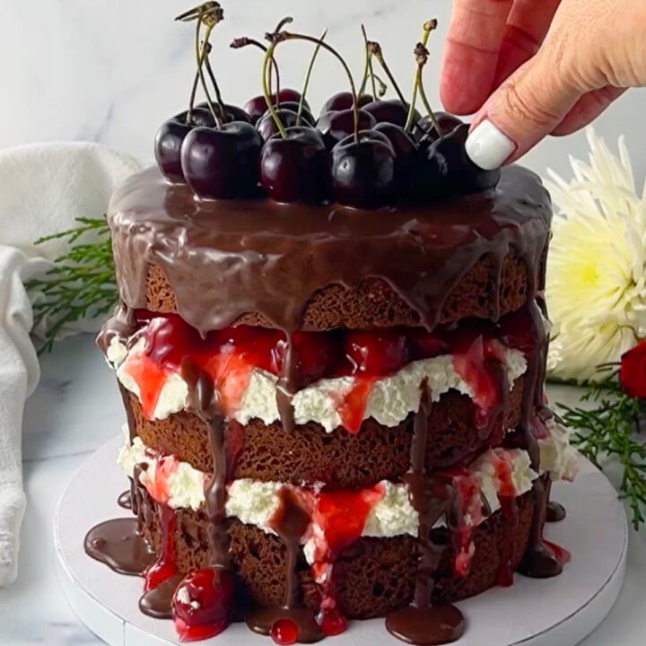 Easy black forest cake with fresh cherries on top.