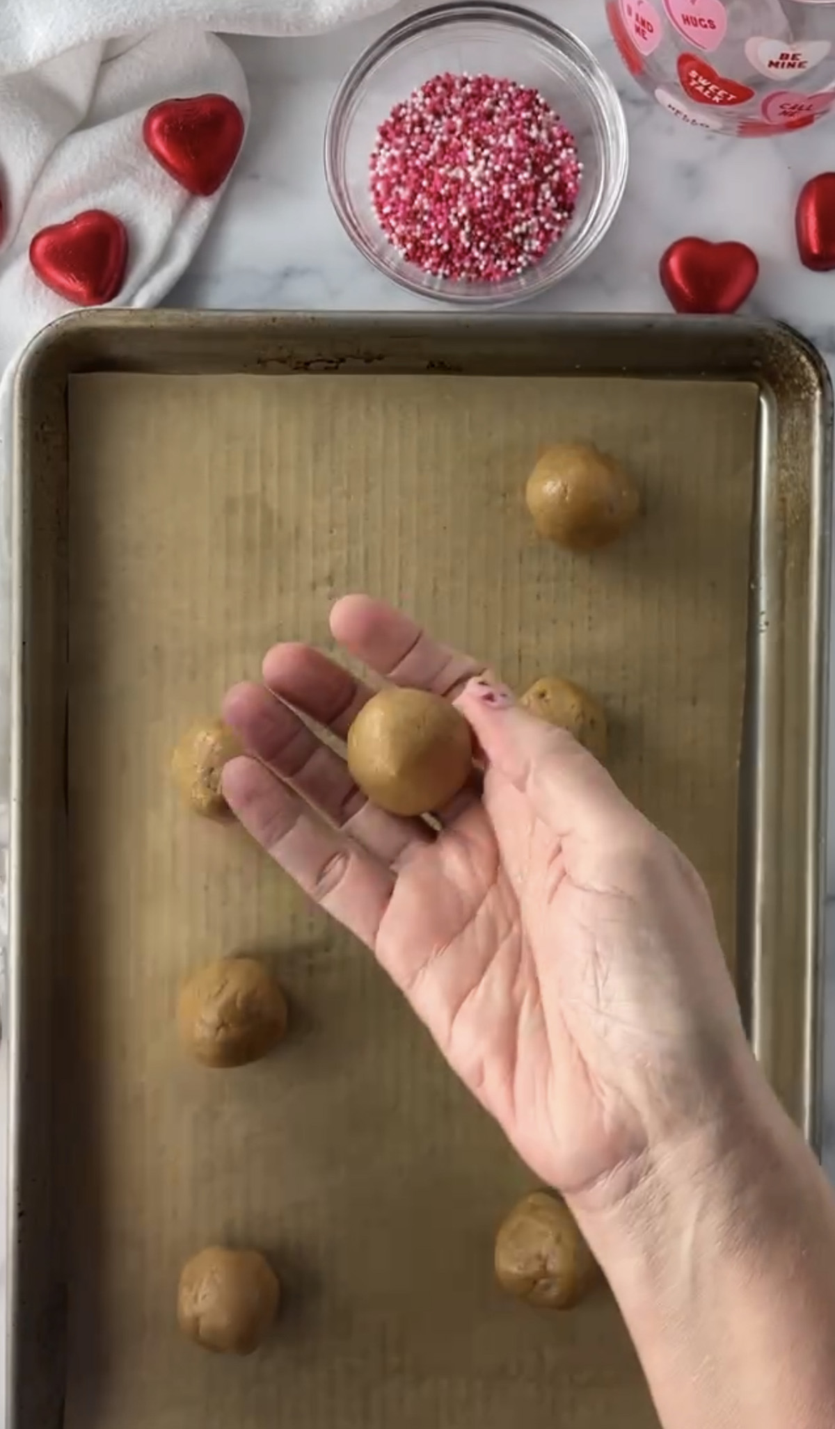 Rolling peanut butter balls with hands.