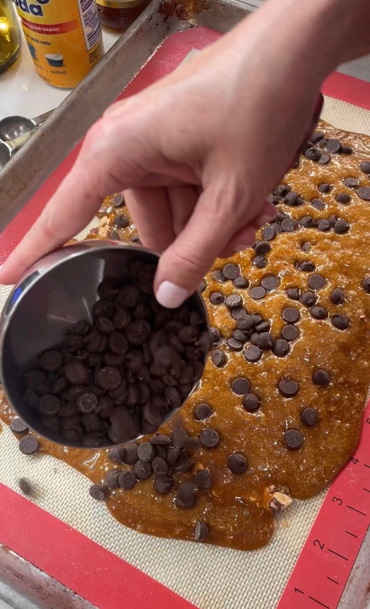 Adding chocolate chips to hot toffee.