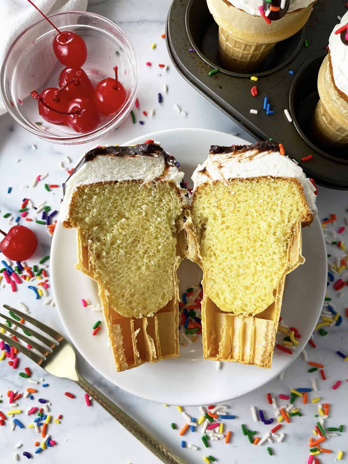 An ice cream cone cupcake cut open to show the yellow cake inside the cone.