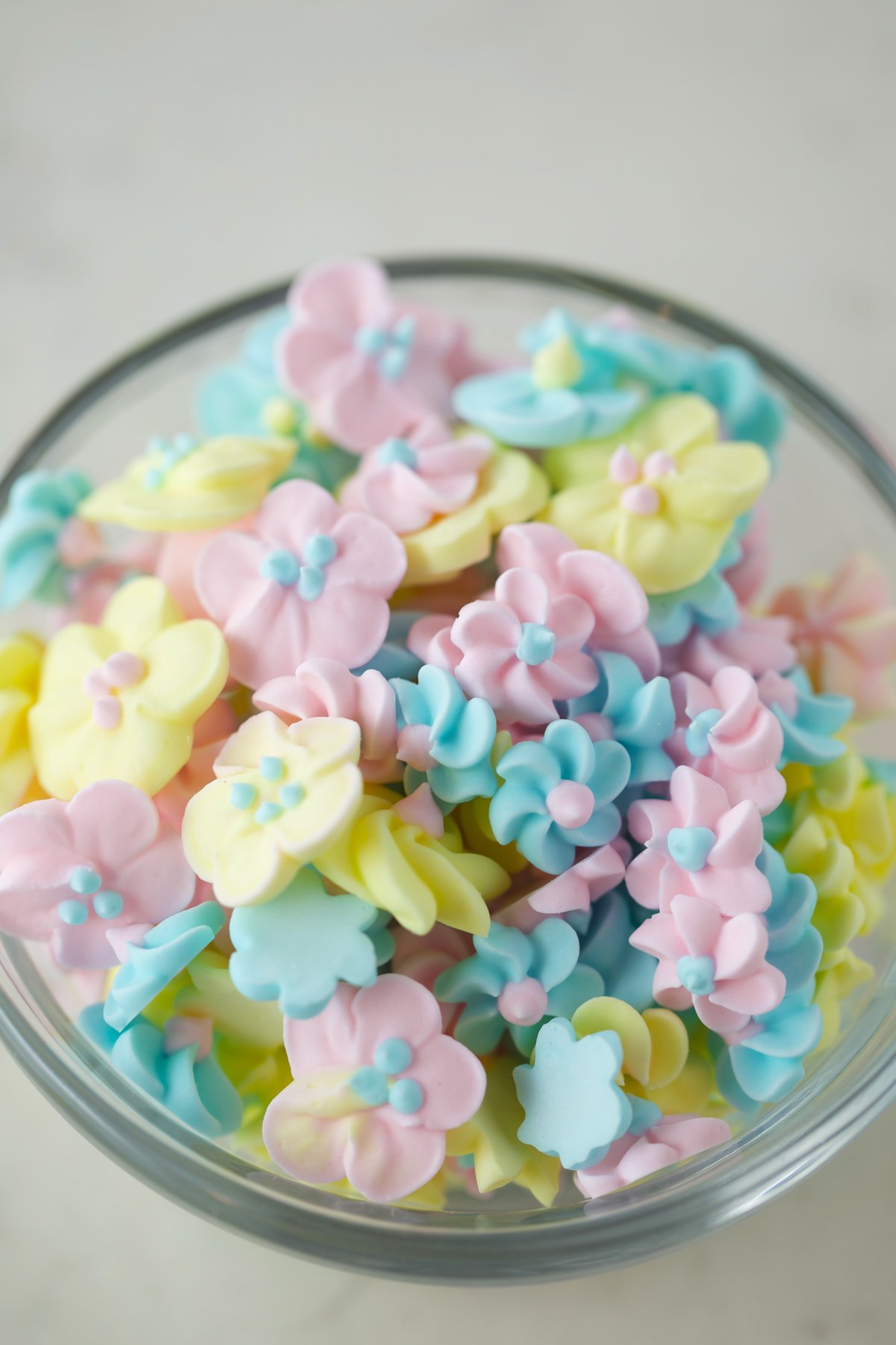 Royal icing flowers in a glass bowl.