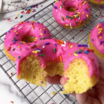 Pink cake mix donut with bite taken out.