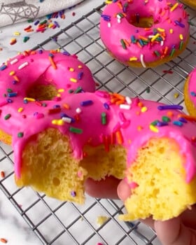 Pink cake mix donut with bite taken out.