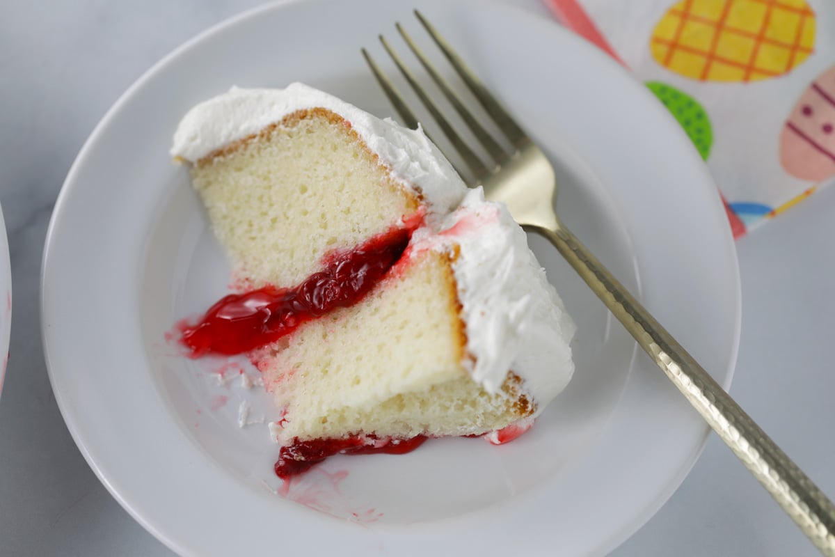 Slice of vanilla cake with strawberry fruit filling.