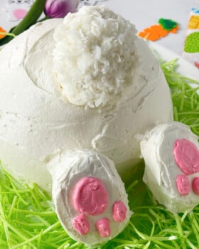 Cute bunny butt vanilla cake on a bed of green coconut grass.