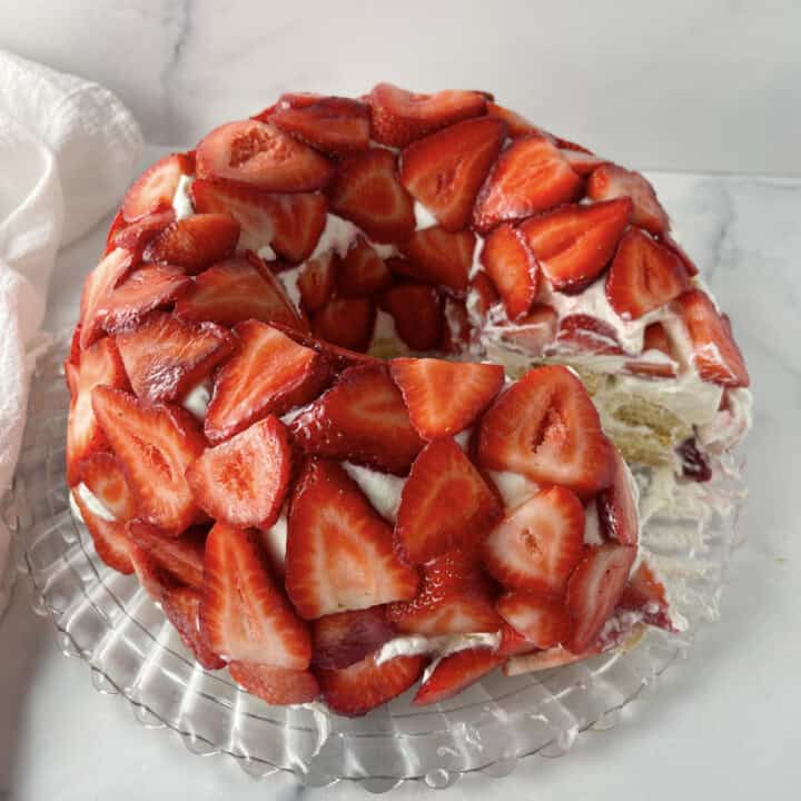 Tiramisu with Strawberries on a crystal cake platter.