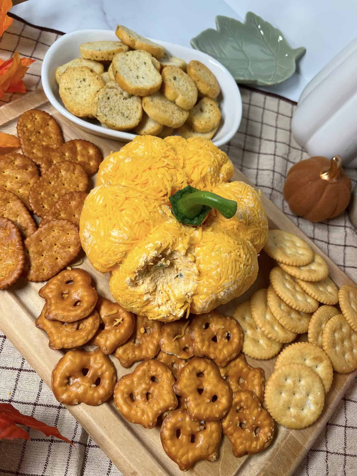 Appetizer tray with pumpkin shaped cheeseball and crackers.
