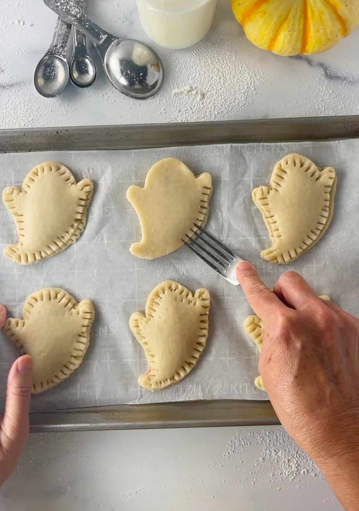 Crimping edges of pie crust with a fork.