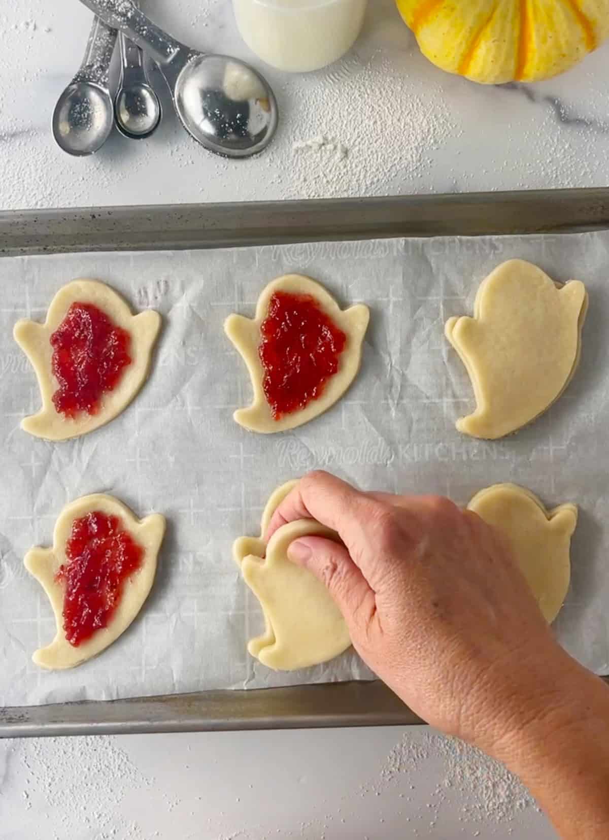Adding the strawberry filling to homemade pop tarts before baking.