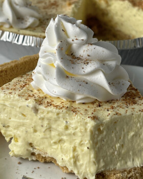 Slice of cream eggnog pie with whipped cream on top.