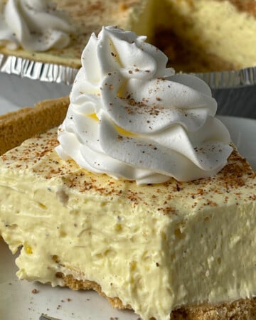 Slice of cream eggnog pie with whipped cream on top.