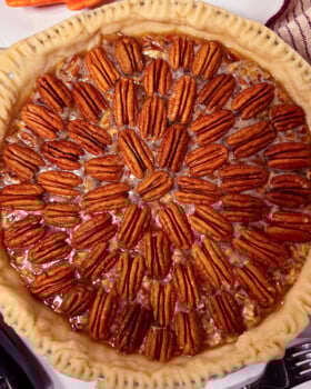 Pecan pie in homemade pie crust and pretty pecan design on top.