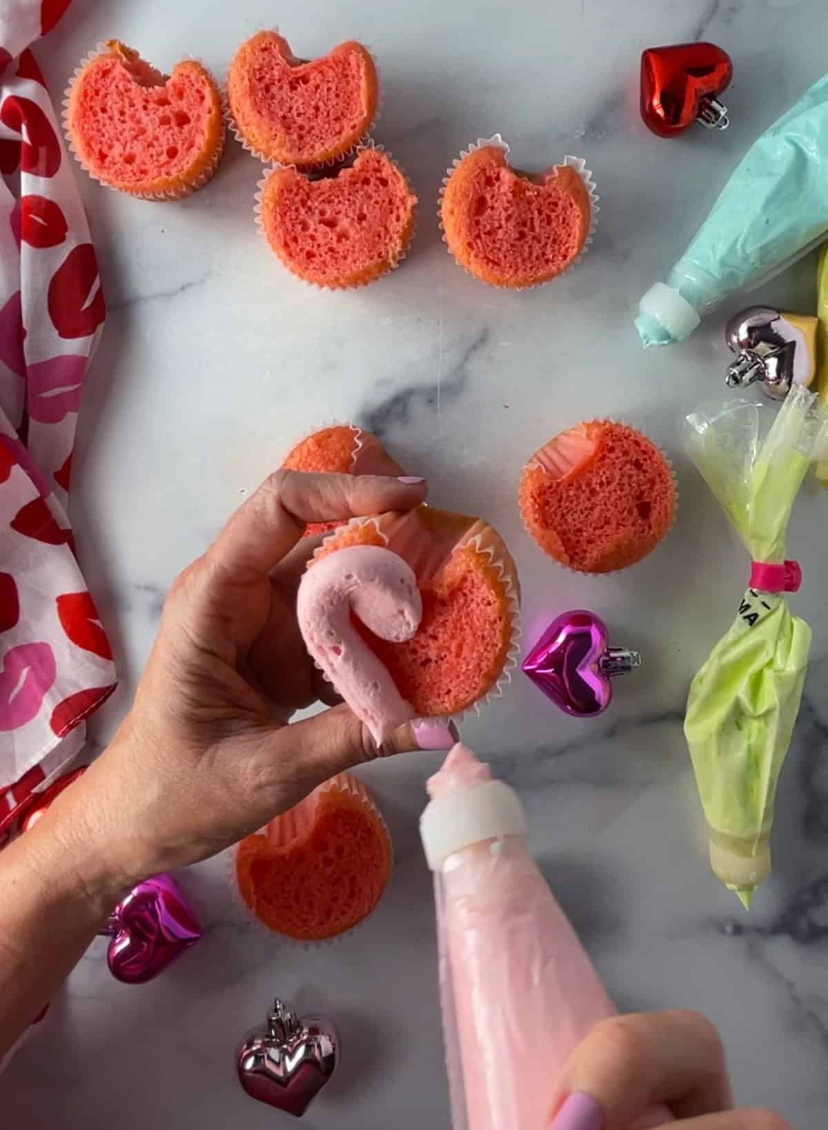 Piping buttercream onto cupcakes.