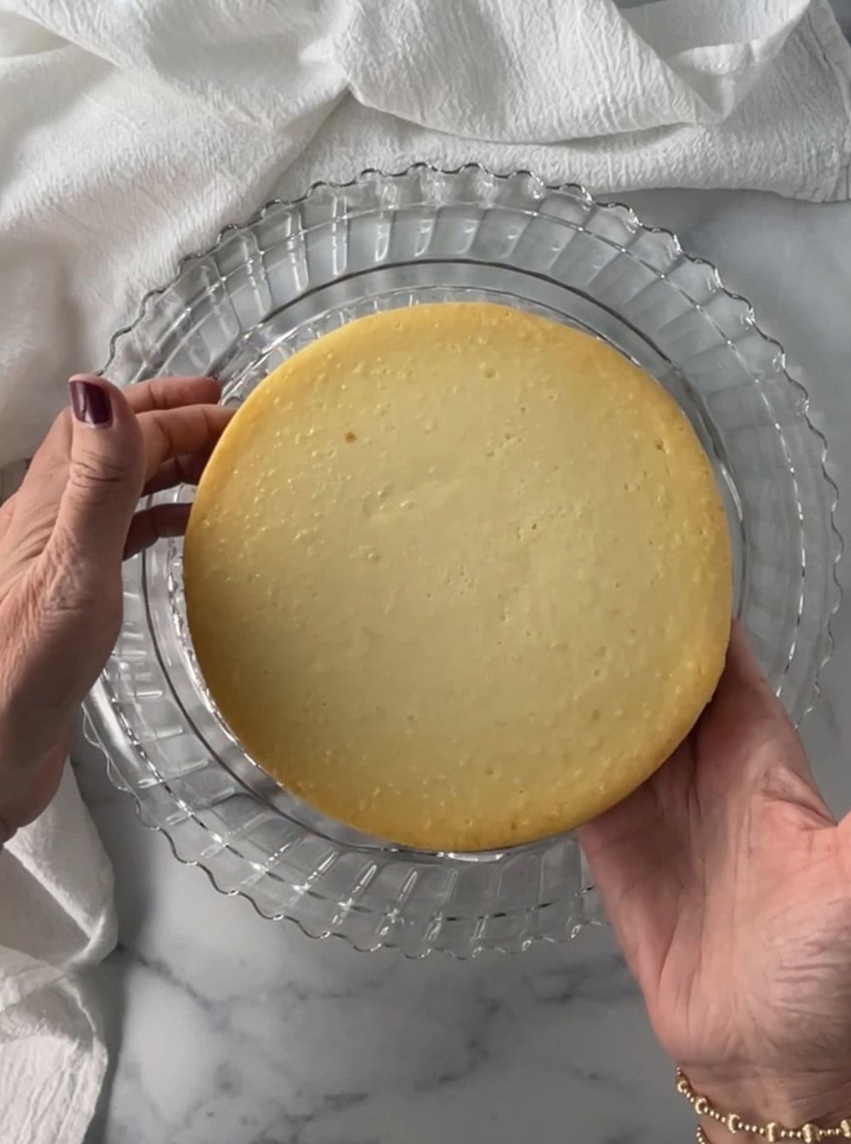 Frozen New York Style cheesecake on a glass plate.
