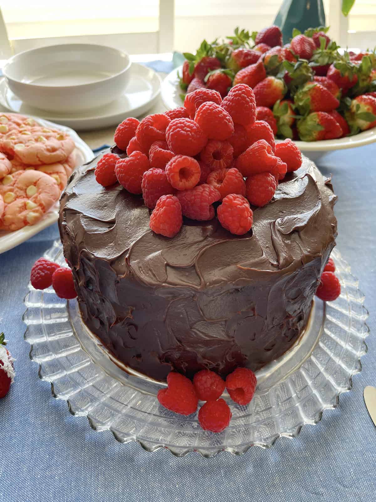 Chocolate layer cake with fresh raspberries piled on top.