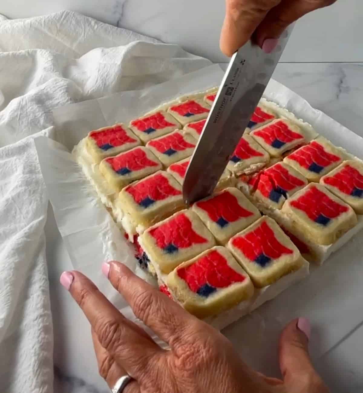 Cutting the flag cookie ice cream sandwiches into squares to serve.