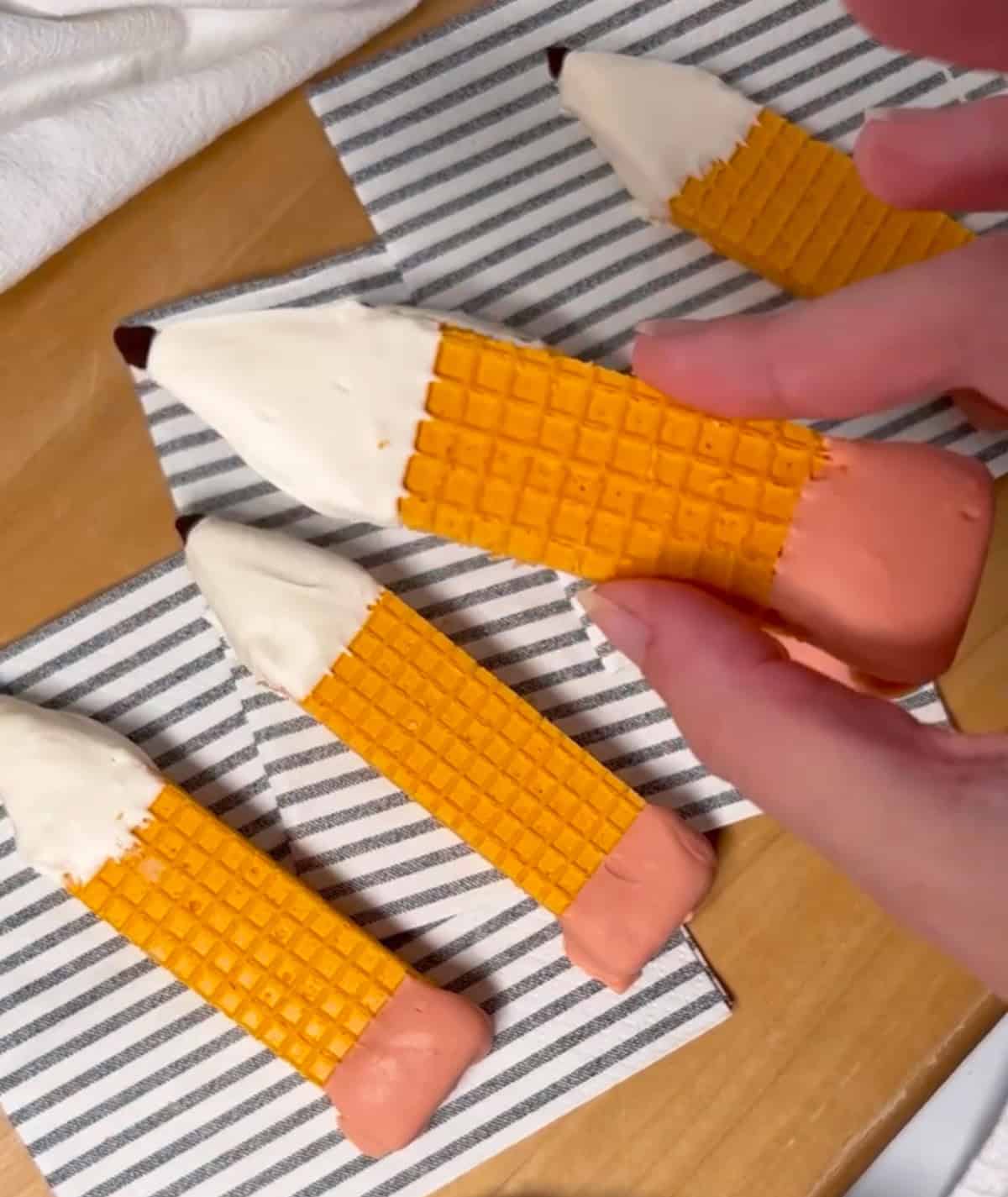 Finished pencil cookies made from sugar wafers dipped in candy melts with chocolate chip tips.