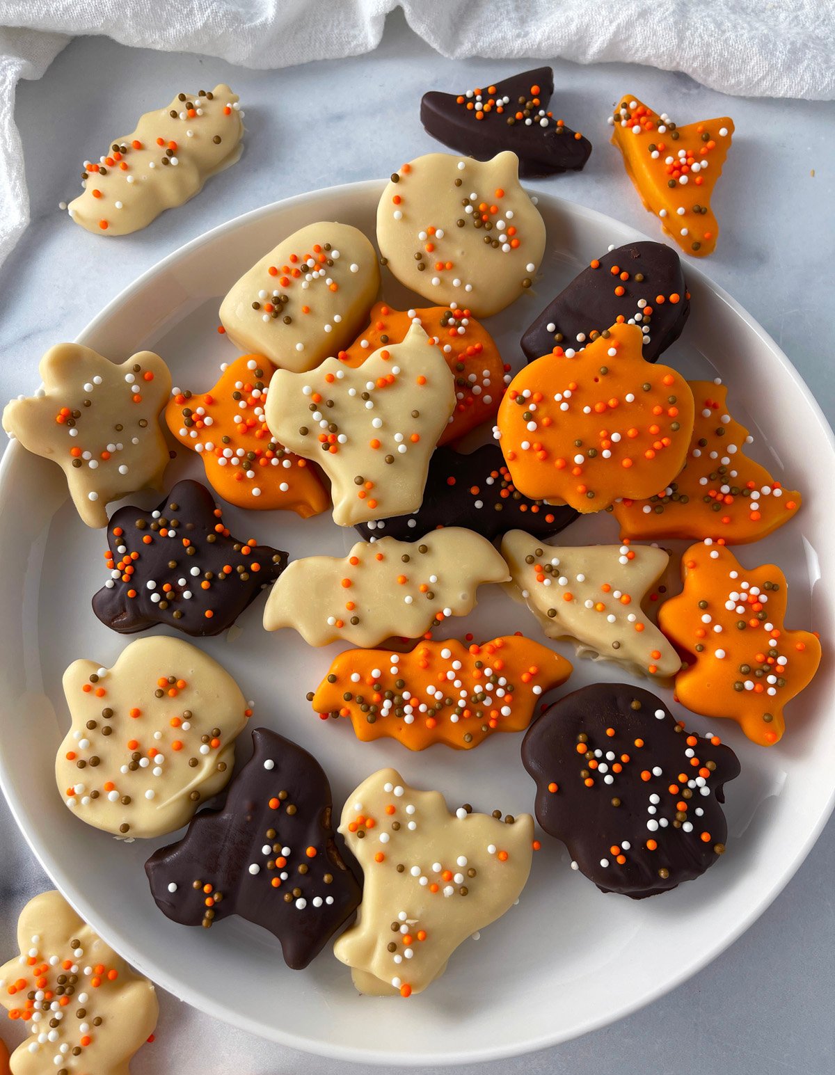 A plate filled with decorated Halloween cookies ready to serve.