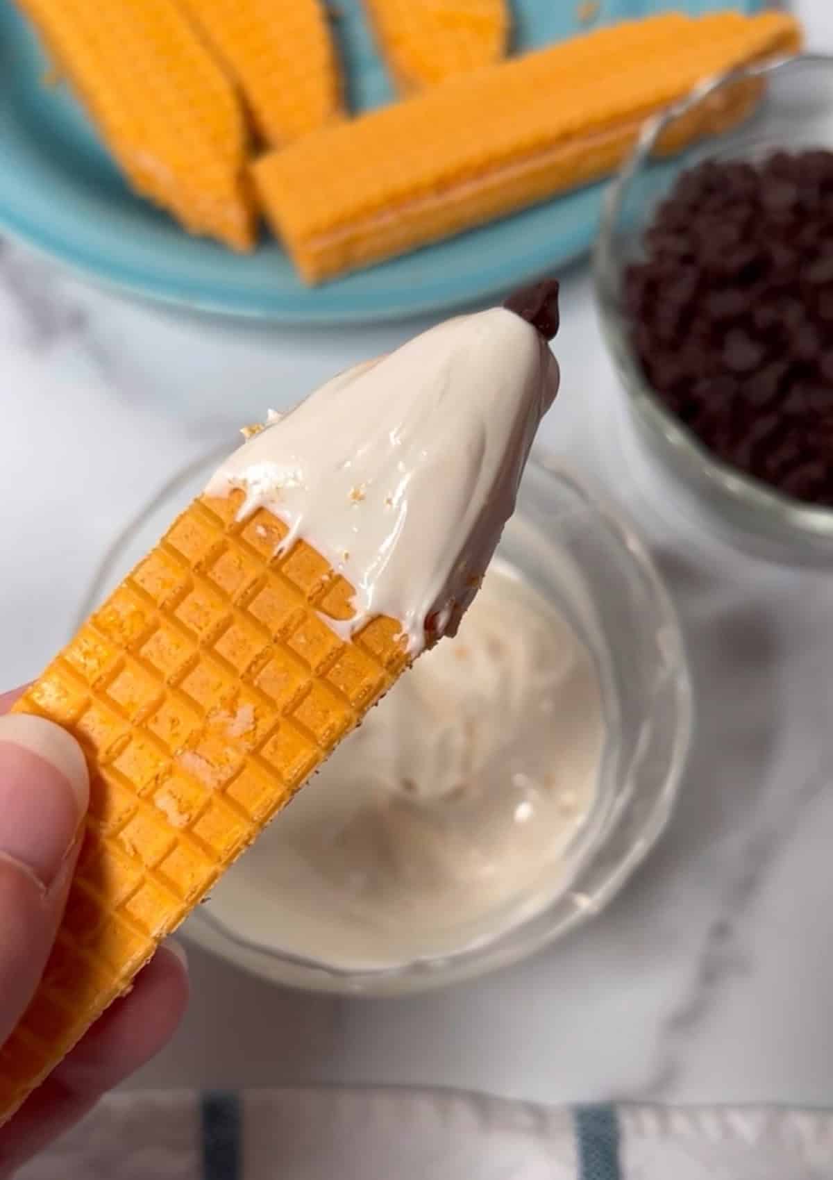 Close-up of a sugar wafer dipped in white candy melts to look like a pencil tip.