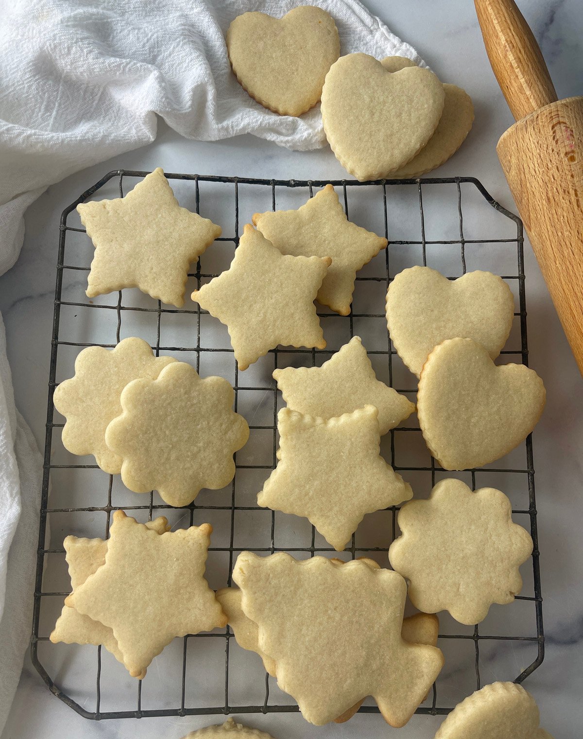 Assortment of baked cut out sugar cookies on a cooling rack.