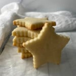 Stack of golden star-shaped sugar cookies with crisp edges, perfect for decorating.
