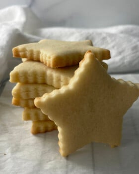 Stack of golden star-shaped sugar cookies with crisp edges, perfect for decorating.