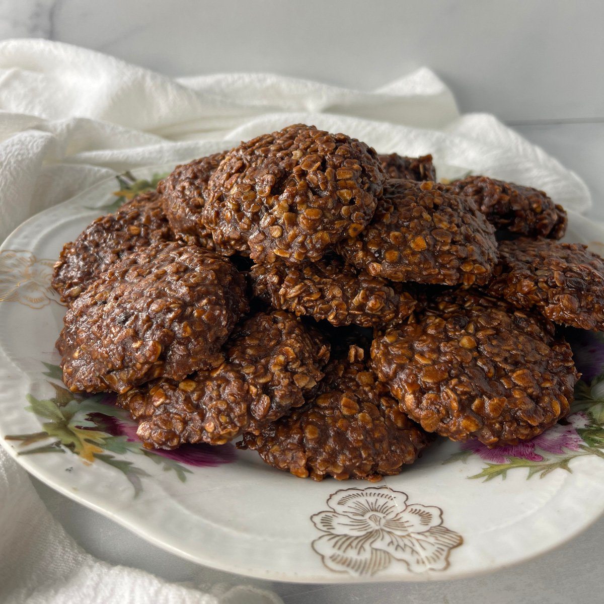 Plate of no bake chocolate oatmeal cookies stacked and ready to serve.