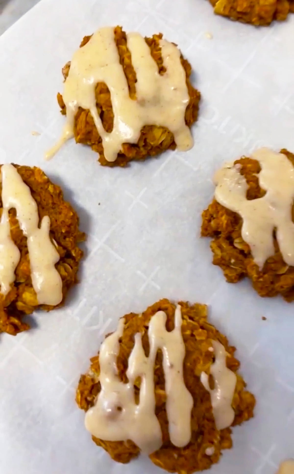 Tray of pumpkin oatmeal cookies with shiny brown butter icing, ready for a fall gathering.