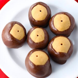 Plate of homemade chocolate dipped peanut butter buckeyes on a white platter, ready to serve.
