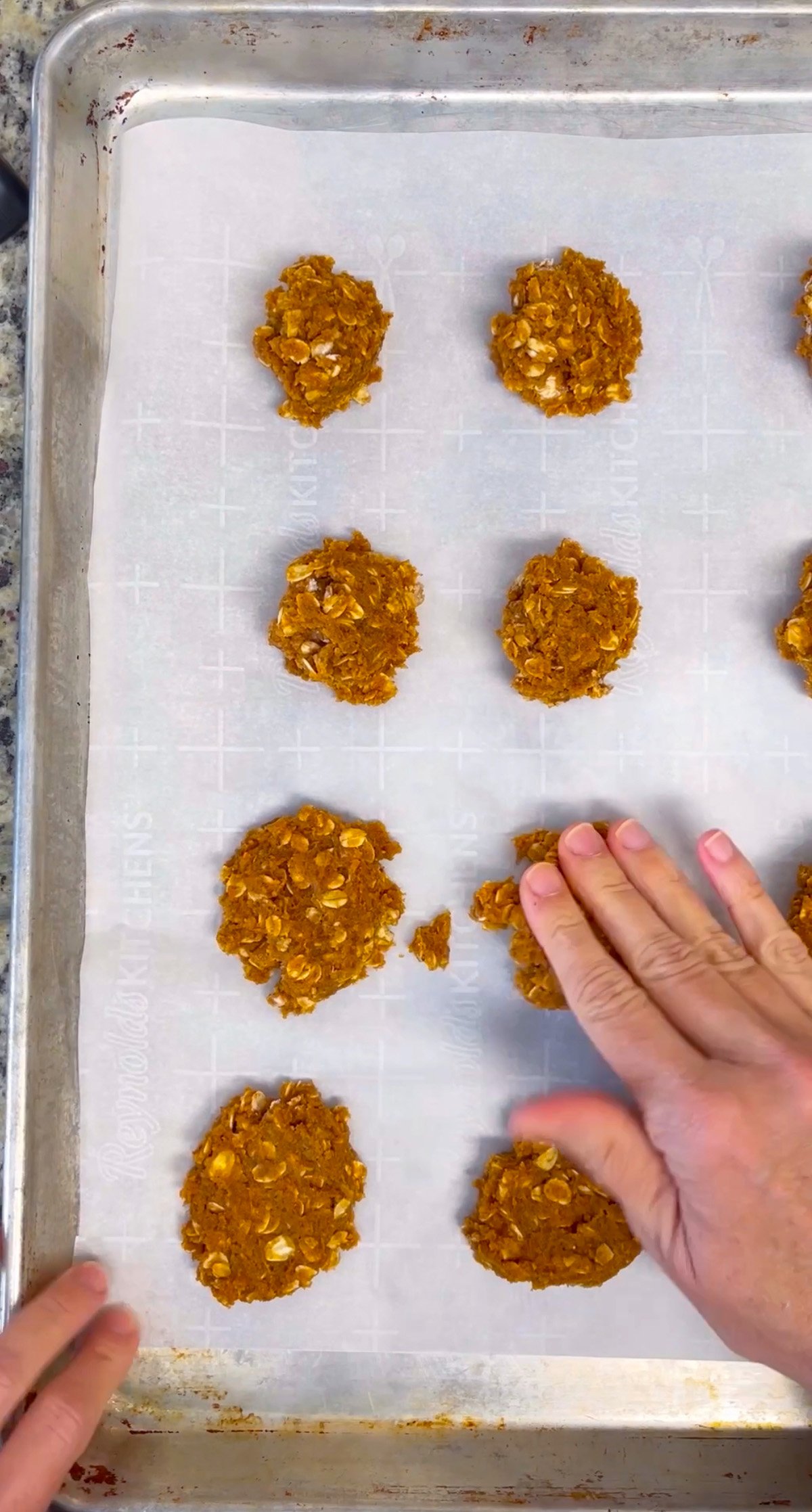 Baking sheet filled with pumpkin oatmeal cookies cooling on parchment paper.