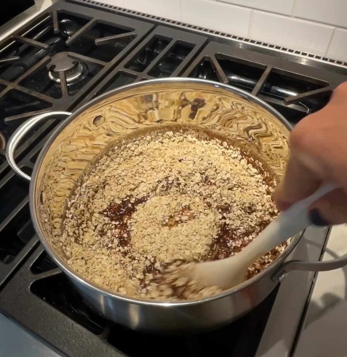 Stirring oats into the chocolate mixture to make no bake chocolate oatmeal cookies.