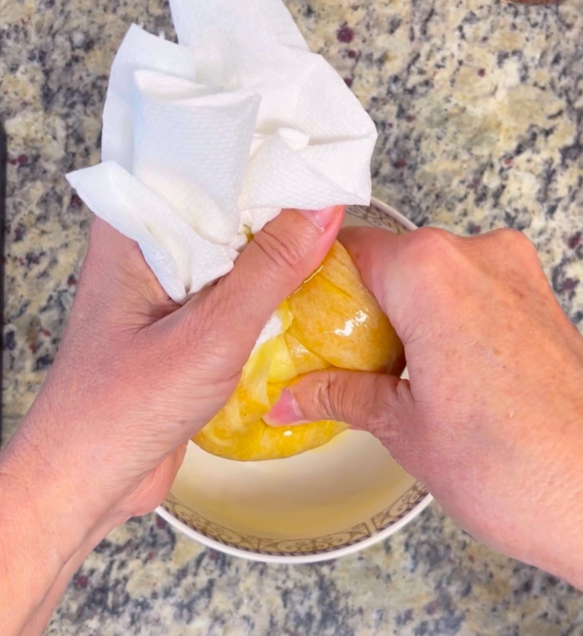 Pumpkin puree in a bowl being blotted with paper towels to remove excess moisture before baking.