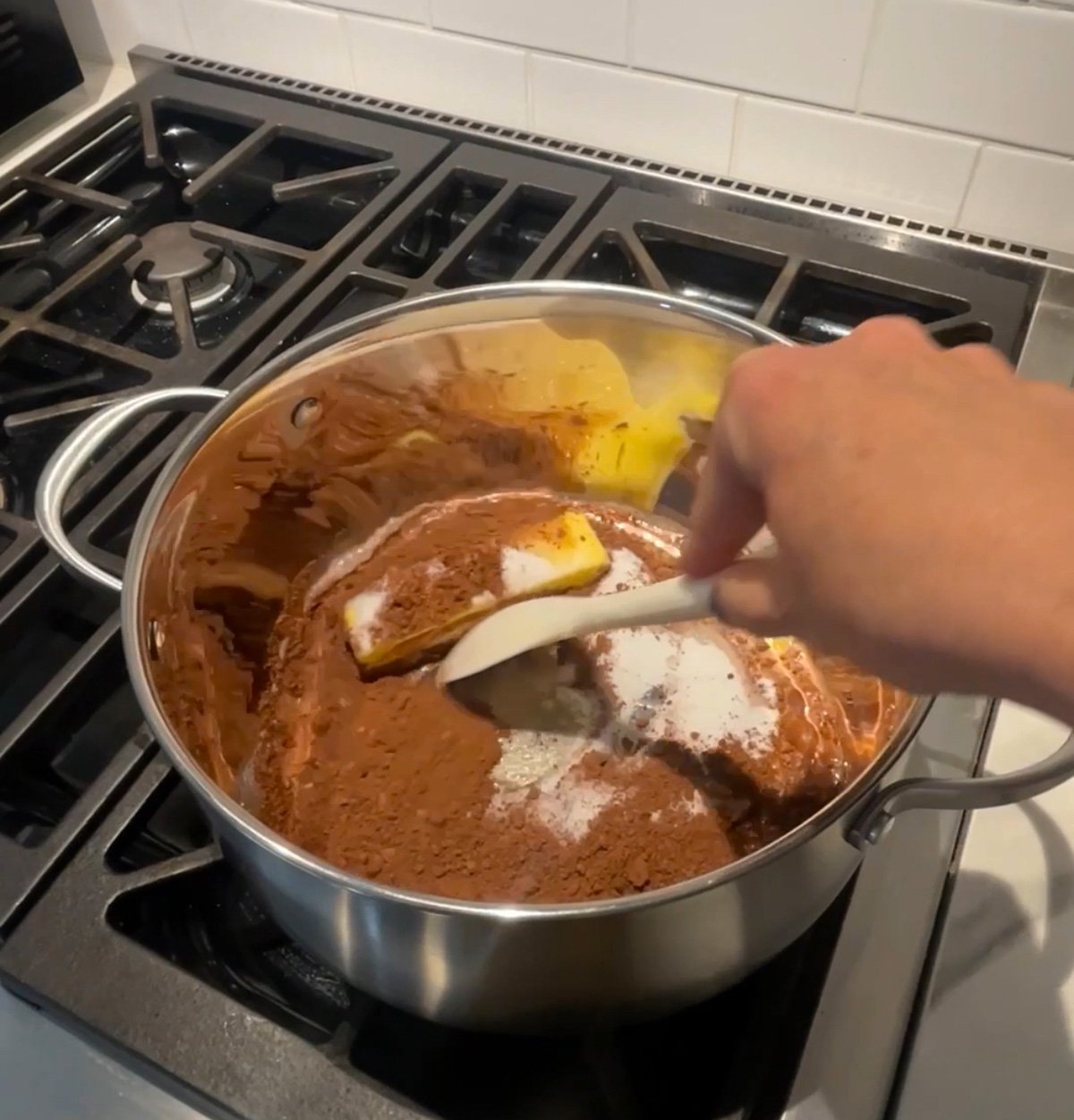 Stirring the boiled mixture of butter, sugar, milk, and cocoa for no bake chocolate oatmeal cookies.