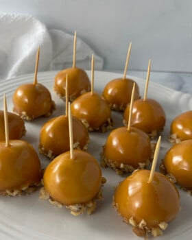 White plate filled with caramel apple cookies topped with drizzled caramel.