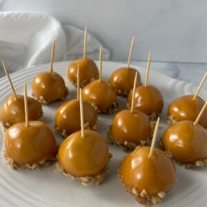White plate filled with caramel apple cookies topped with drizzled caramel.