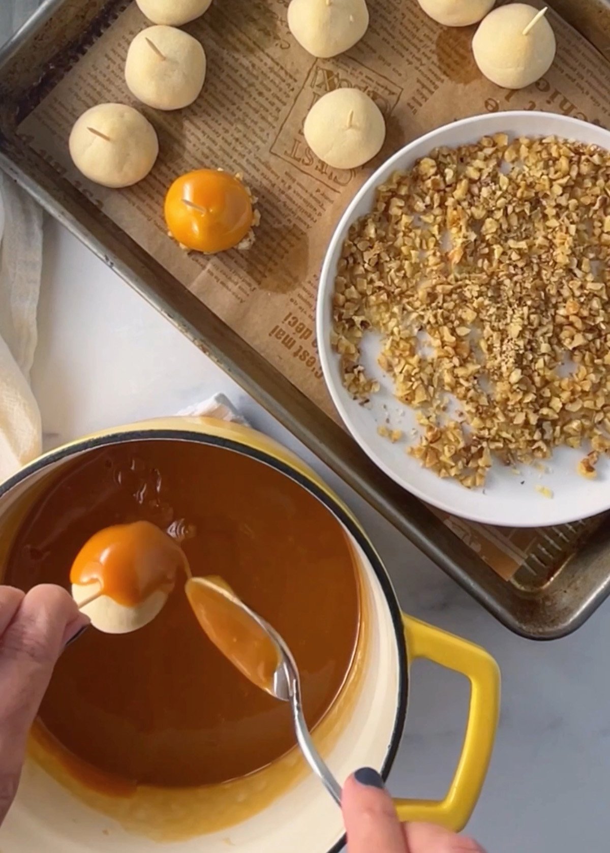 Spooning caramel sauce over baked cookie ball.