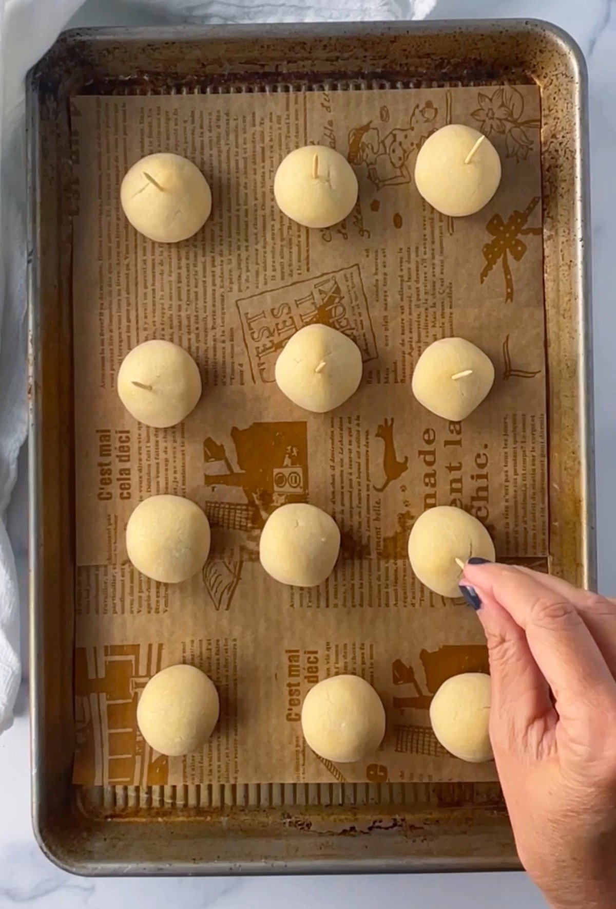 Baked caramel apple cookie balls with toothpicks inserted on top to resemble mini caramel apples.