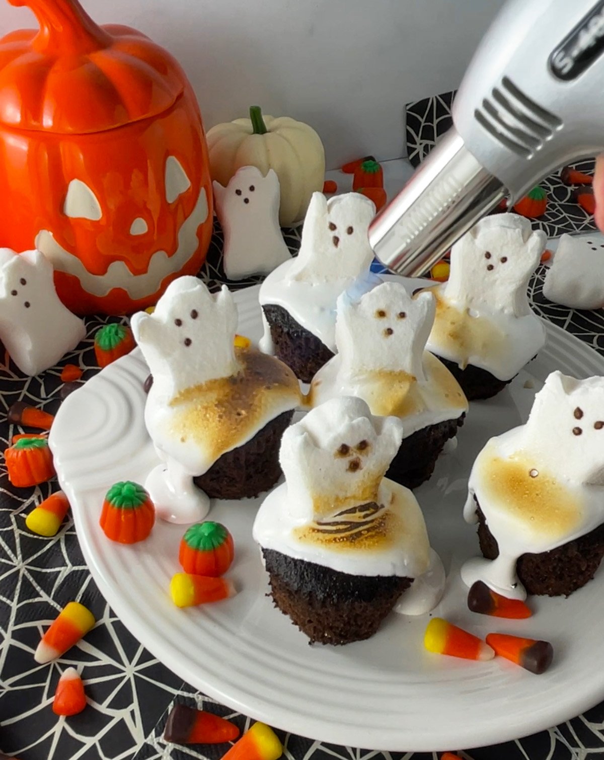Toasting marshmallow cupcakes with kitchen torch.