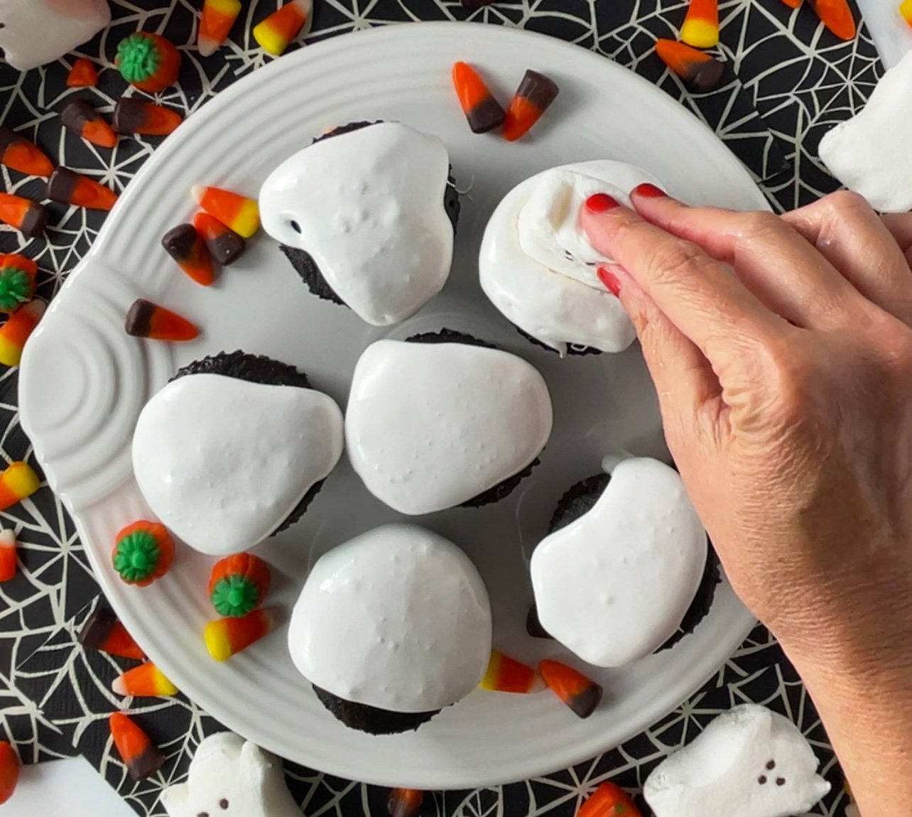 Halloween cupcakes with ghost peeps on top.